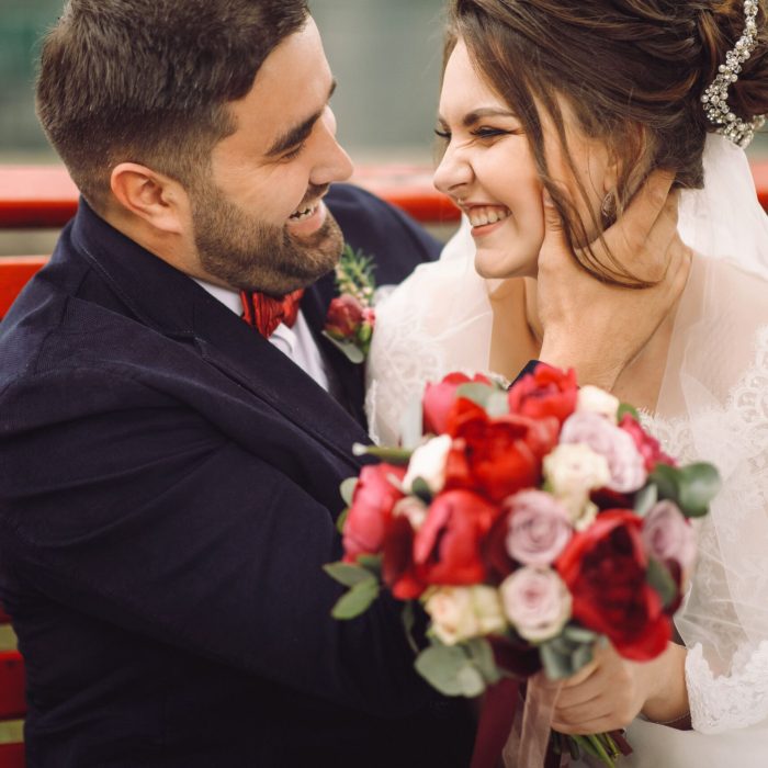 bride-groom-have-fun-hugging-kissing-bench-outside (1)